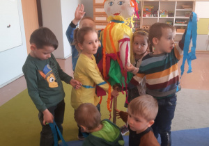 Dzieci z grupy 3-4 latków ubierają kukłę marzanny